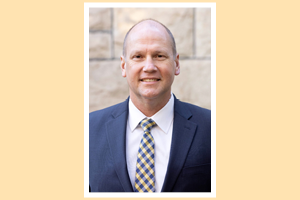Background: Rich Ballou in front of block wall