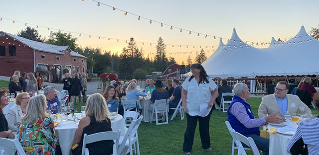 Background: Group of people at an outdoor event - Caption: None.